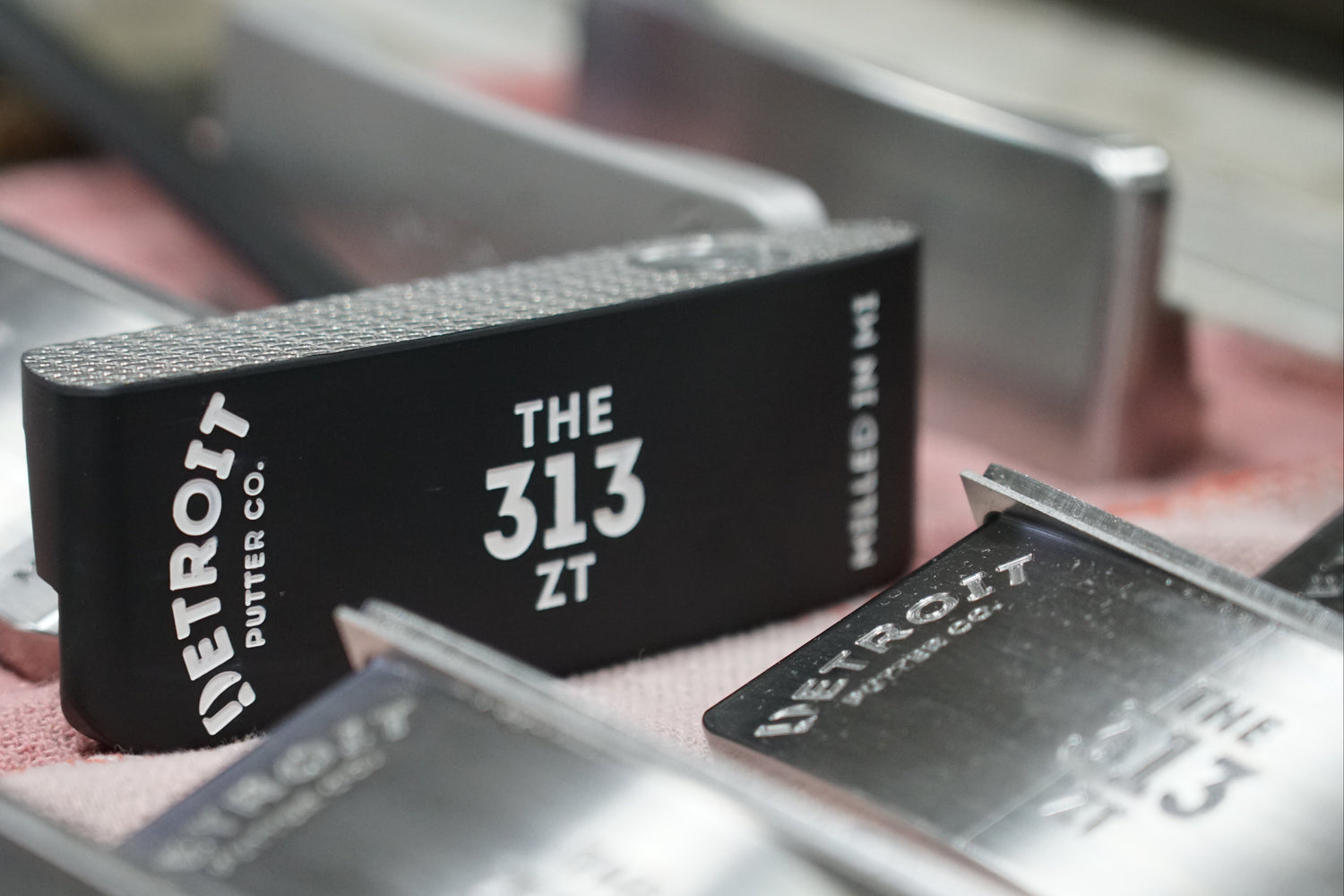 Black rubber stamp with 'The 313 Detroit Duster Co.' branding on a metal surface.